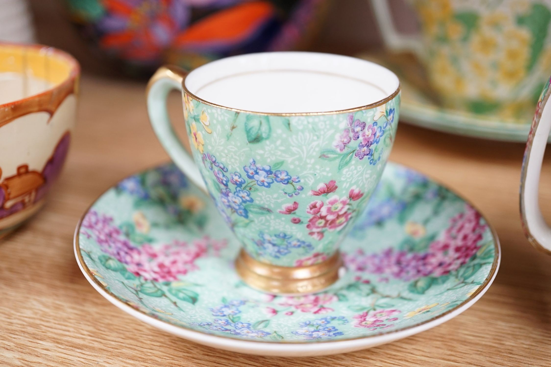 A Clarice Cliff tea cup, a collection of chintz patterned teaware, a lustre bowl and a honey pot and cover